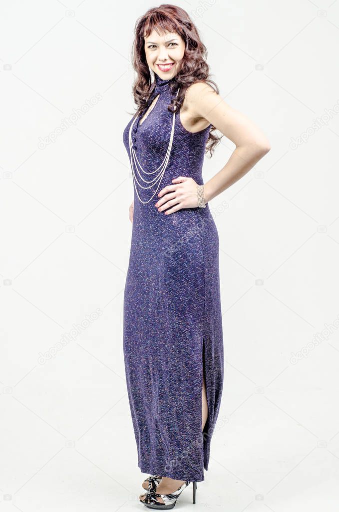 Beautiful blonde woman in a dark blue long cocktail dress with sequins