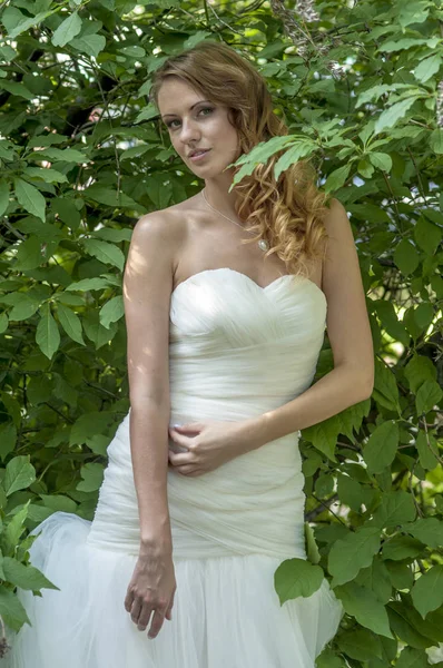 Gadis muda dengan rambut merah rambut indah dan riasan dalam gaun putih pengantin di taman — Stok Foto