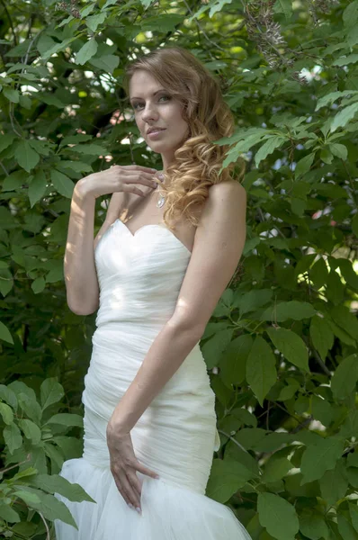 Jong meisje met rood haar mooi haar en make-up in een witte jurk van de bruid in het park — Stockfoto