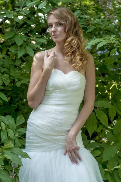 Jong meisje met rood haar mooi haar en make-up in een witte jurk van de bruid in het park — Stockfoto