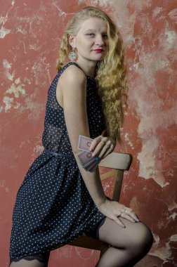 Polka noktalı uzun elbise ve iskambil ile çorap sarı kıvırcık saçlı genç kız