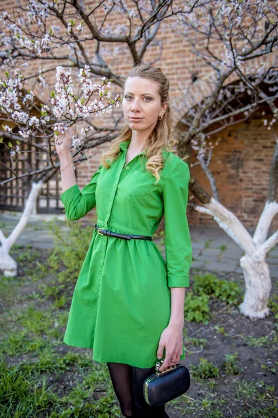 Jeune fille blonde sur le fond d'un jardin fleuri de printemps — Photo