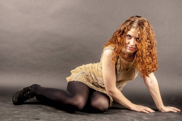 Portrait of a beautiful young red curly girl with bright makeup