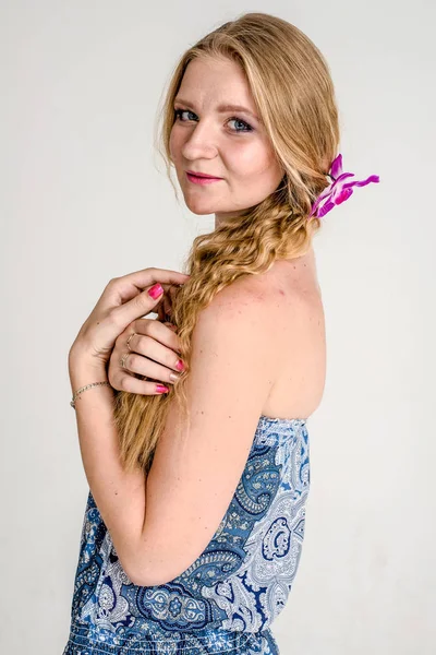 蘭の花と夏のドレスで金髪の美しいロマンチックな女の子 — ストック写真