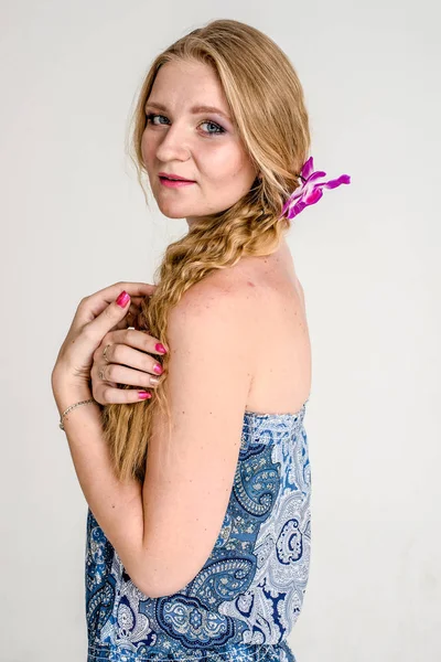 Schöne romantische Mädchen Blondine im Sommerkleid mit Orchideenblume — Stockfoto