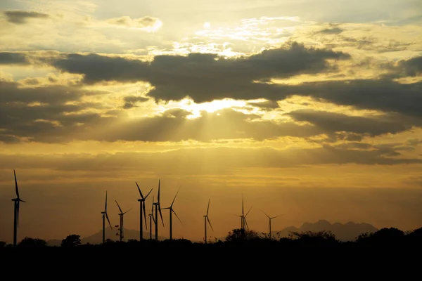 Windturbines als silhouetten tegen een prachtige zonsondergang met stralen van de zon schijnt neer — Stockfoto