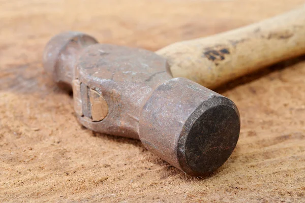 Macro shot of an old rusty ball peen hammer on a wooden table — Stock Photo, Image