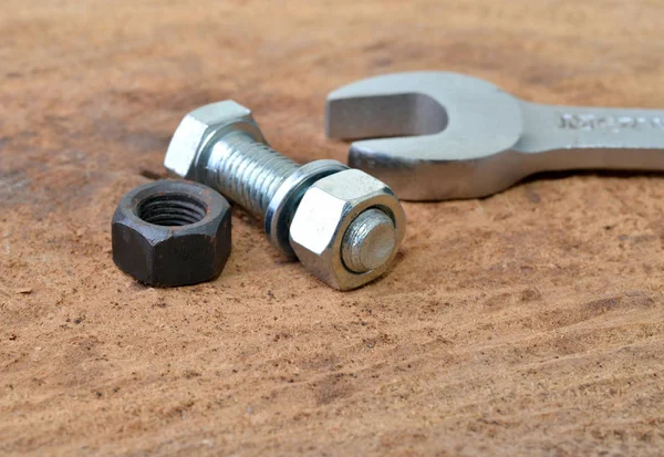 Macro tiro de perno, tuercas y una llave en una mesa — Foto de Stock