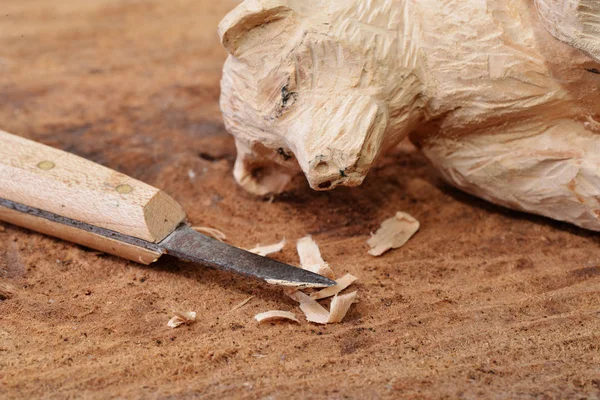 Macro shot of a wood carving knife some shavings and a carved figure — Stock Photo, Image
