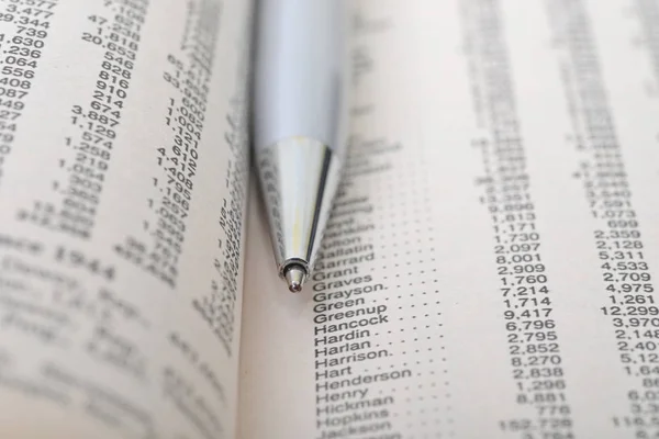 Macro shot of a silver pen in between a book pages — Stock Photo, Image