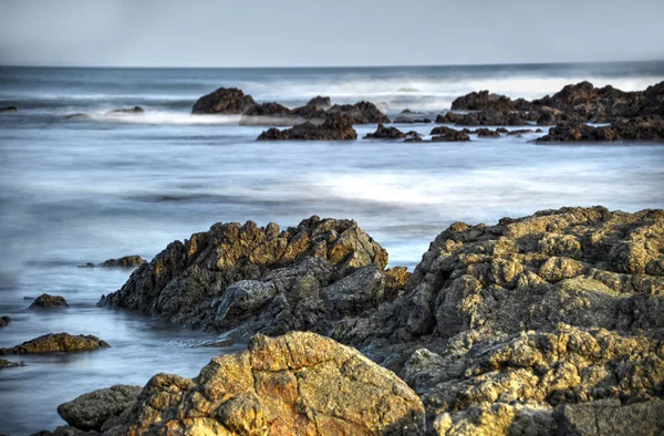 Larga exposición de rocas marinas bañadas por el agua del océano — Foto de Stock