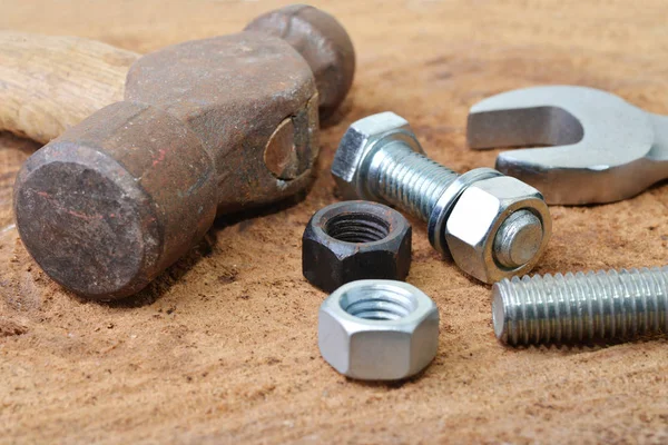 Macro shot of some tools with bolts and nuts on a wooden table top — Stock Photo, Image