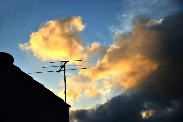 Silhouette image of an old analog roof tv antenna with a sunset background — Stock Photo, Image