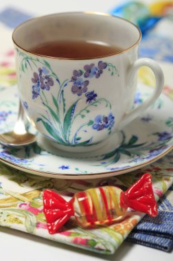 Bir çiçek deseni ve şeker peçeteye ile güzel bir fincan çay