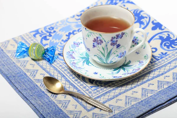 Чай в красивой чашке с цветочным узором на салфетке — стоковое фото