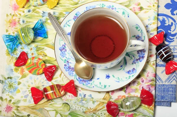 Belle tasse en porcelaine avec thé et bonbons sur une serviette — Photo