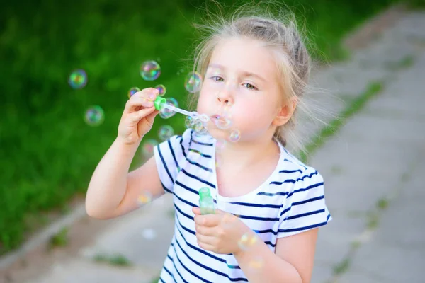 Malá holka foukající mýdlové bubliny — Stock fotografie