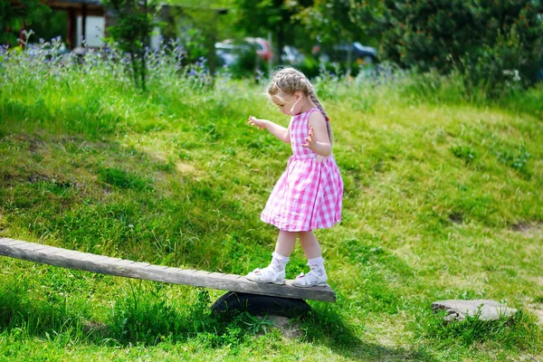 Adorable petite fille marchant sur le bois le jour ensoleillé d'été — Photo