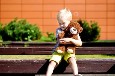 Çok güzel üzgün çocuk oyuncak ayı Park ile.