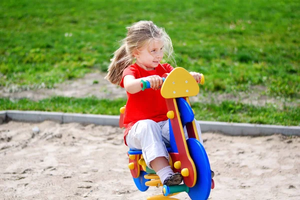 Eğlenceli bir oyun alanı üzerinde açık havada yaz aylarında olan sevimli küçük kız — Stok fotoğraf