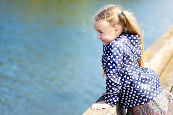 Αξιολάτρευτο κοριτσάκι παίζει από ένα ποτάμι σε ηλιόλουστο πάρκο σε μια όμορφη καλοκαιρινή μέρα — Φωτογραφία Αρχείου