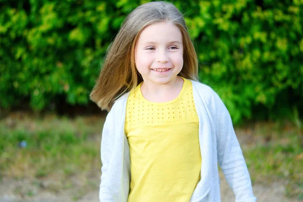 Очаровательная маленькая девочка улыбается в парке — стоковое фото