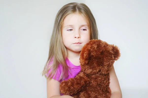 Átölelve egy mackó szomorú kislány — Stock Fotó