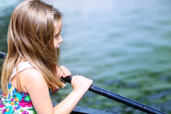 Aranyos kislány nézi folyó, egy szép nyári napon — Stock Fotó