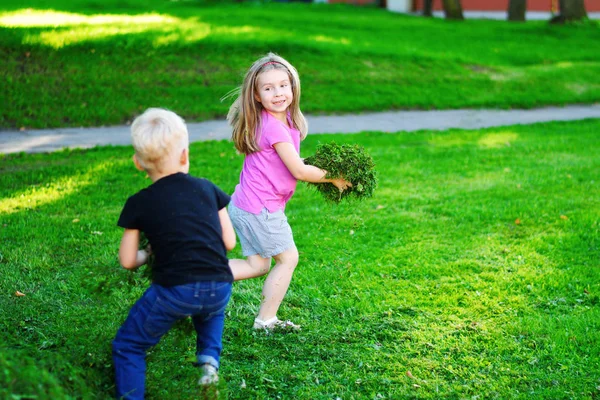 Adorables enfants jouant avec l'herbe coupée — Photo