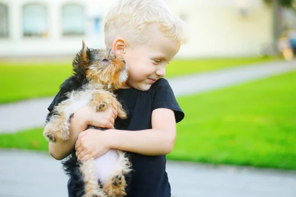 Schattig jongetje met zijn puppy buiten spelen — Stockfoto