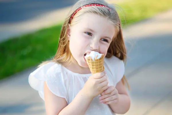 Adorabile bambina che mangia gustoso gelato al parco nella calda giornata estiva soleggiata — Foto Stock