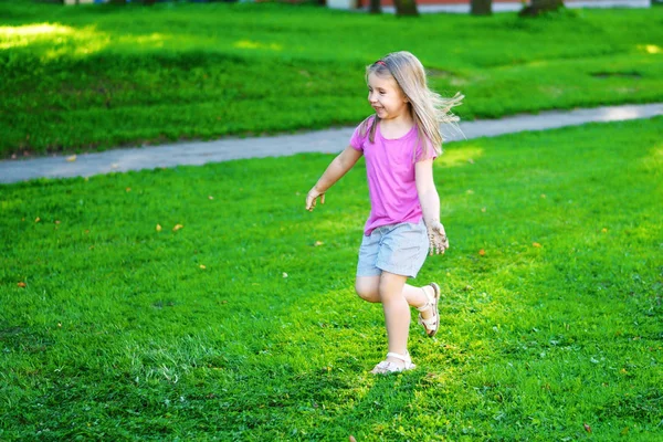 Entzückendes kleines Mädchen läuft auf der Wiese — Stockfoto