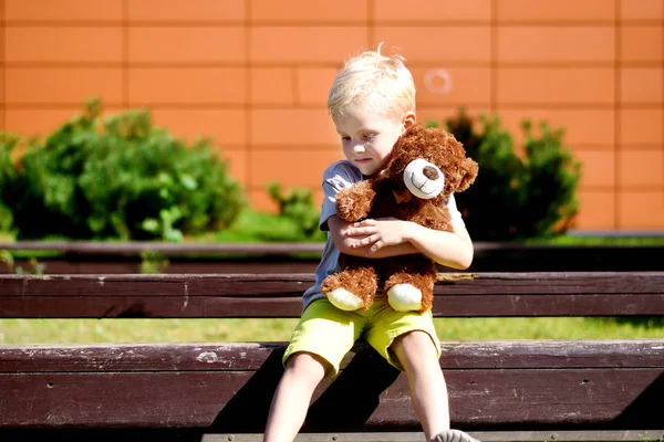 Adorable sad boy with teddy bear in park. — Stock Photo, Image