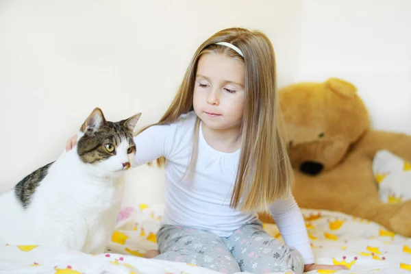 Entzückendes Mädchen mit Katze ruht auf einem weichen Sofa — Stockfoto