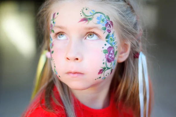 愛らしい少女の顔に彼女の花を取得塗装 — ストック写真