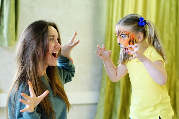 Adorável menina pintada como tigre brincando com animador Imagem De Stock