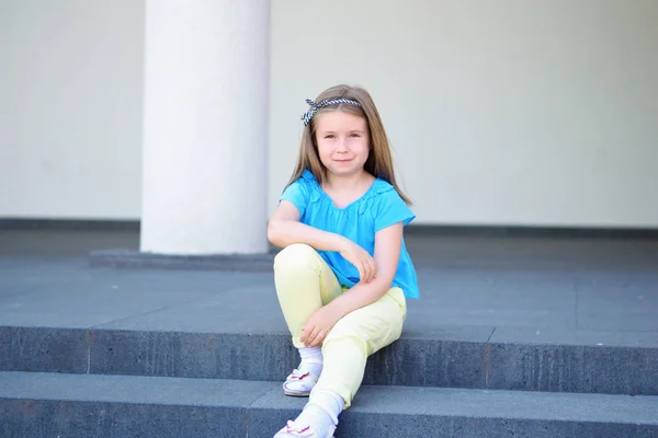 Entzückende kleine schöne Mädchen sitzt auf einer Treppe — Stockfoto