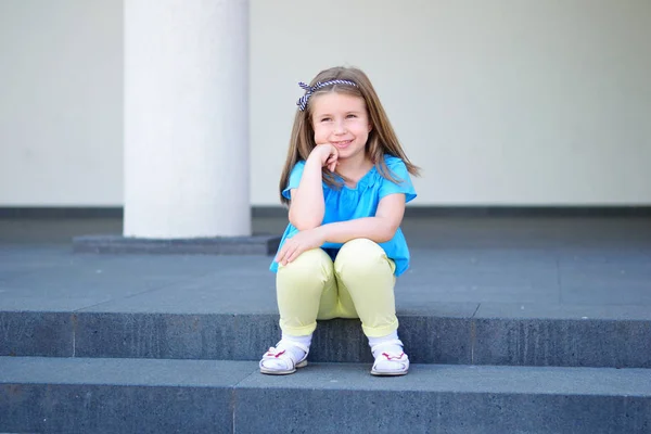 Entzückende kleine schöne Mädchen sitzt auf einer Treppe — Stockfoto