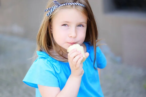 Adorável menina comendo saboroso sorvete no parque no dia ensolarado quente do verão Fotografia De Stock