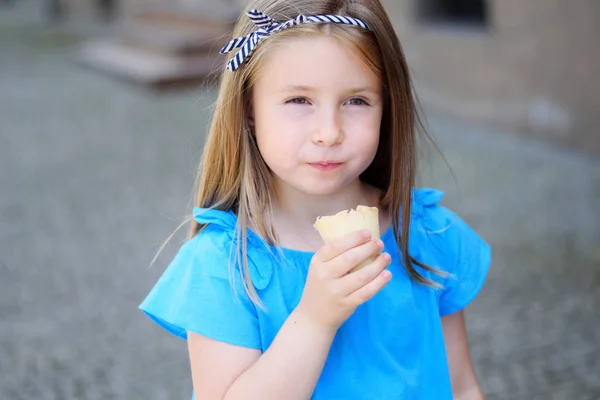 Adorável menina comendo saboroso sorvete no parque no dia ensolarado quente do verão Imagem De Stock