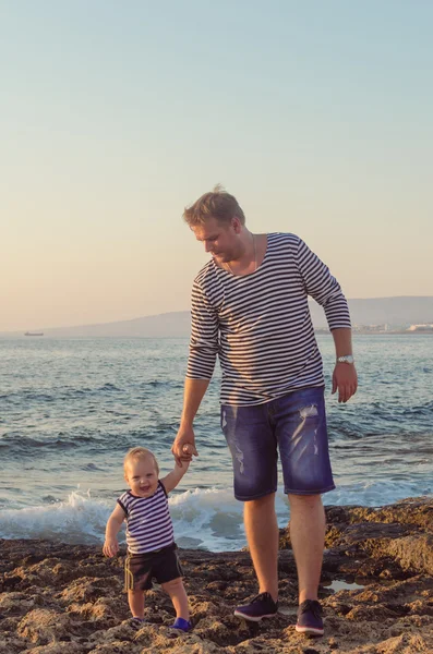 Gilets père et fils marchent sur la plage — Photo