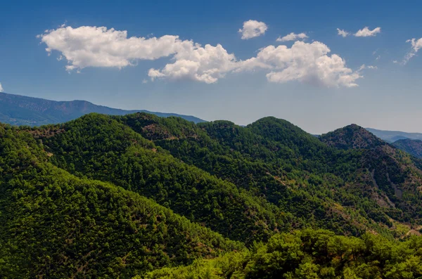Gröna kullar och blå himmel med vita moln — Stockfoto