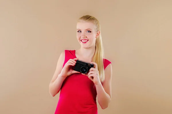 Lovely girl in a bright dress takes pictures old camera — Stock Photo, Image