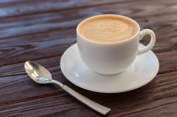 Tazza di caffè in porcellana bianca su tavolo in legno strutturato — Foto Stock