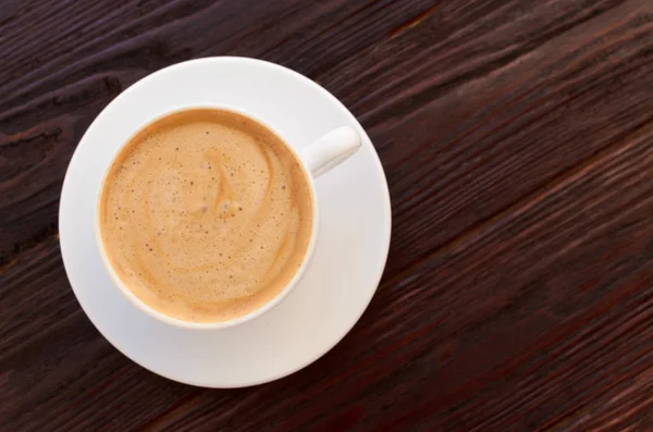 Tazza di caffè in porcellana bianca su tavolo in legno strutturato — Foto Stock