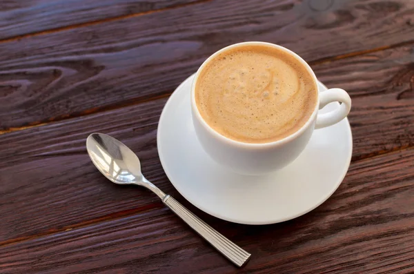 Tazza di caffè in porcellana bianca su tavolo in legno strutturato — Foto Stock