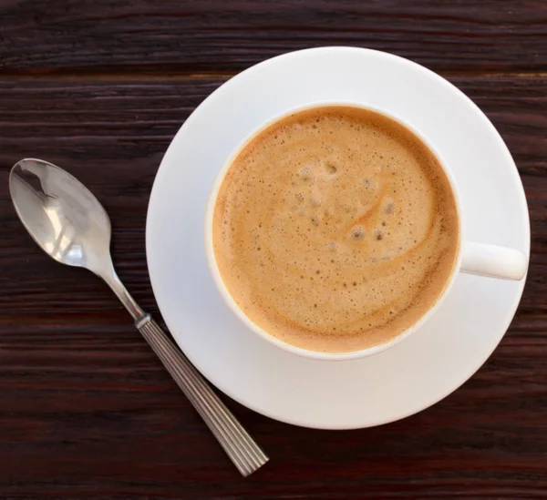 Tazza di caffè in porcellana bianca su tavolo in legno strutturato — Foto Stock