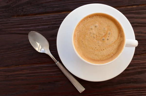 Tazza di caffè in porcellana bianca su tavolo in legno strutturato — Foto Stock