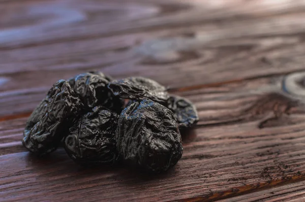 Dried plums (prunes) on the wooden table dark textural