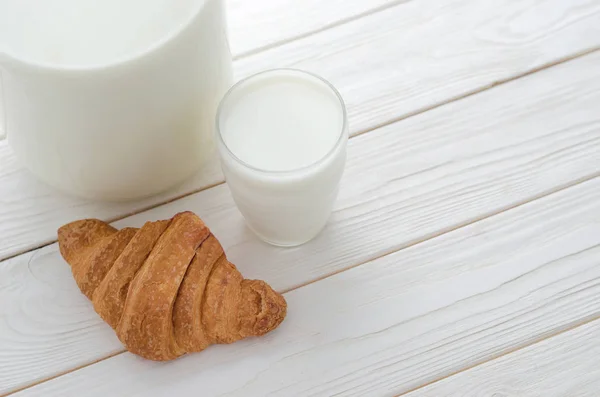 Glas mjölk och en croissant på bordet. — Stockfoto